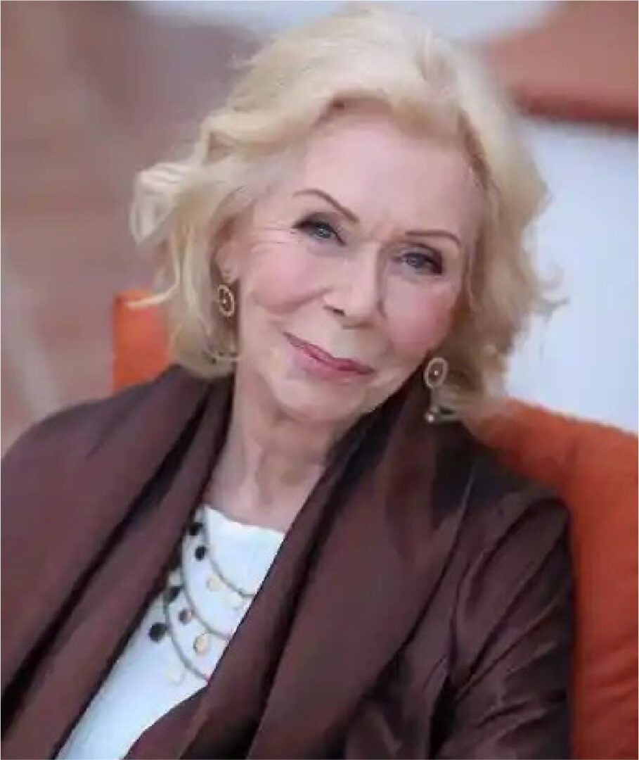 A woman sitting in an orange chair wearing a brown jacket.