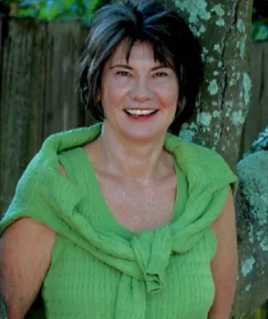 A woman in green shirt smiling for the camera.